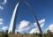 Stunning view of the Gateway Arch in St. Louis, Missouri, against a bright blue sky with clouds.